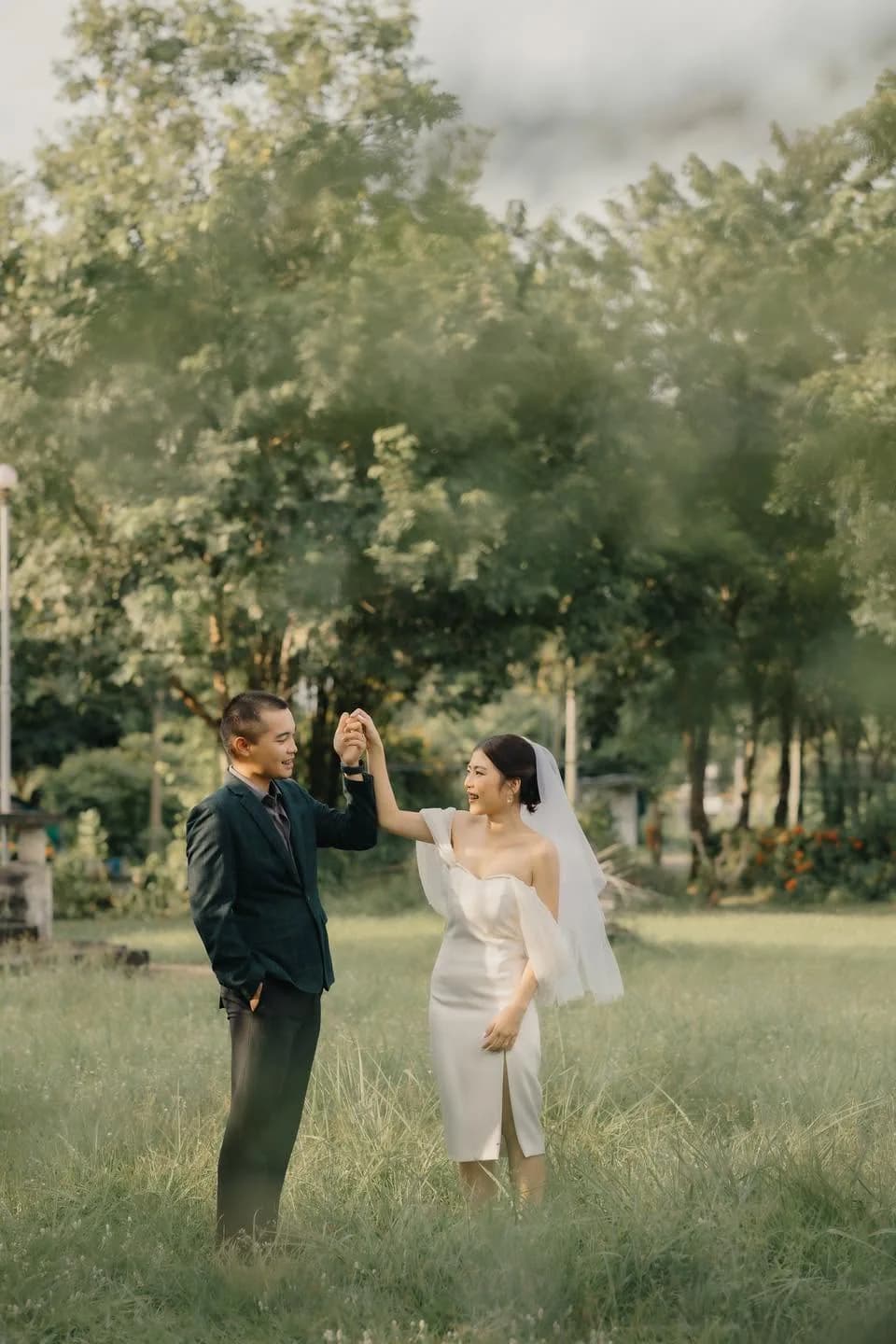 คู่รักจับมือกันท่ามกลางต้นไม้กลางแจ้ง